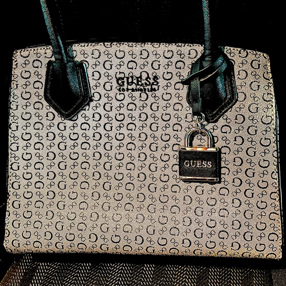 Guess signature print purse with leather zip top and black cloth inside.